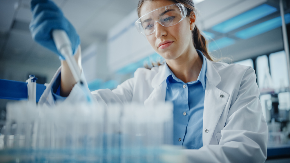 Laboratory scientist using a pipette to process samples for MiDOG veterinary diagnostic testing and microbial analysis.